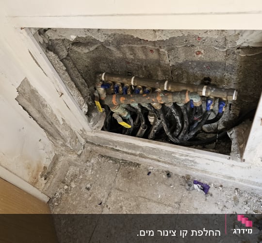 צינורות מים חשופים בקיר עם ברזים